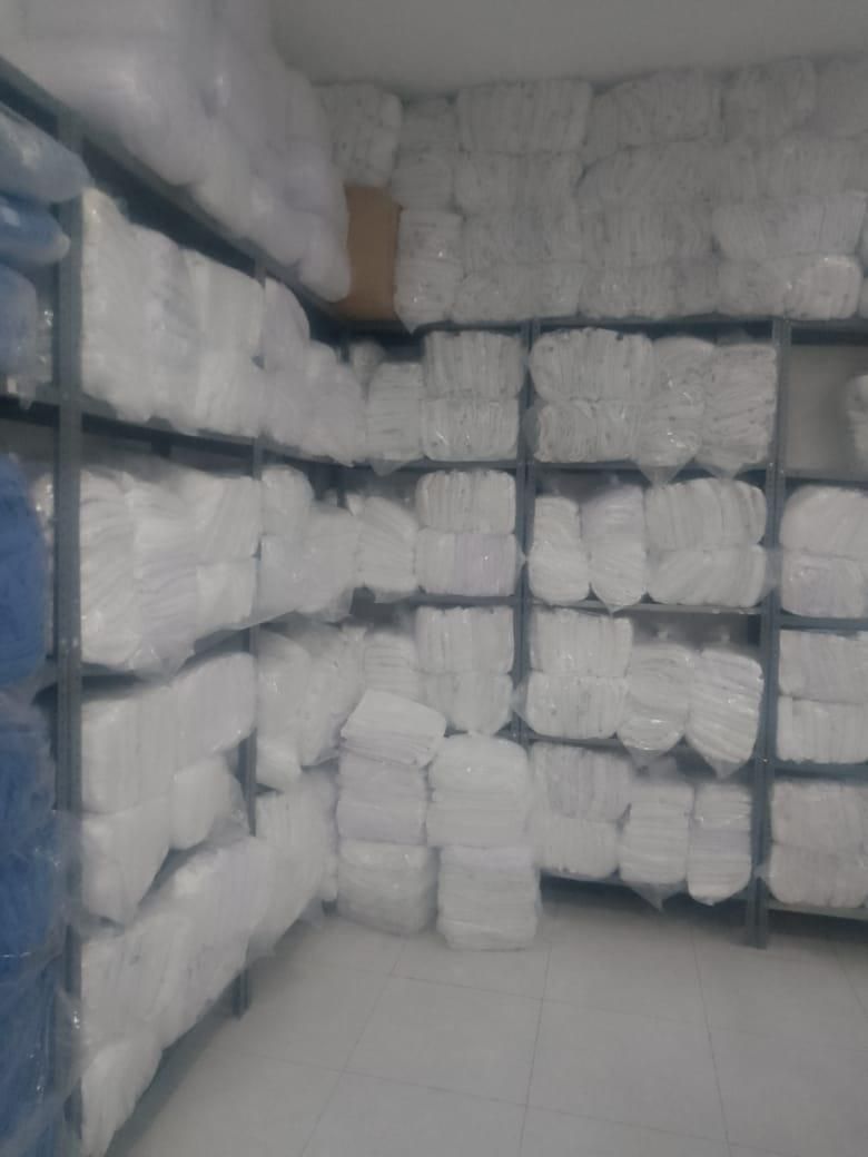Estantería con paquetes de ropa blanca limpia y empacada